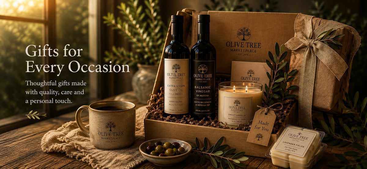 Olive Tree Marketplace gift selection — olive oil and balsamic vinegar bottles, a soy candle and a ribbon-tied kraft gift box with a handwritten tag